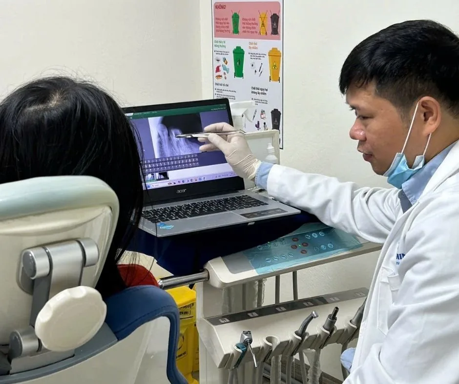 Bác sĩ giải thích tình trạng răng cho khách hàng trên màn hình