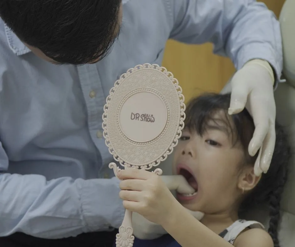 Bé soi gương xem kết quả sau điều trị răng